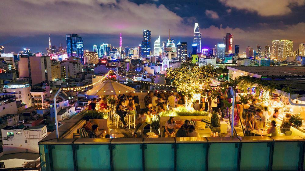 Open rooftop surrounded by greenery and neon lighting gives off a cheerful, modern vibe (Source: Banana Mama)